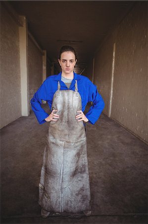 Portrait of female welder standing with hands on hips near corridor Foto de stock - Sin royalties Premium, Código: 6109-08722898