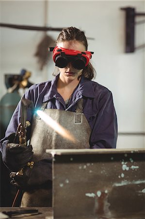 Female welder holding welding torch in workshop Stock Photo - Premium Royalty-Free, Code: 6109-08722804