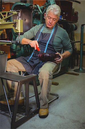 simsearch:6109-08763878,k - Shoemaker repairing a shoe in workshop Stock Photo - Premium Royalty-Free, Code: 6109-08722975