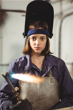 simsearch:6109-08722895,k - Female welder holding welding torch in workshop Foto de stock - Sin royalties Premium, Código: 6109-08722902