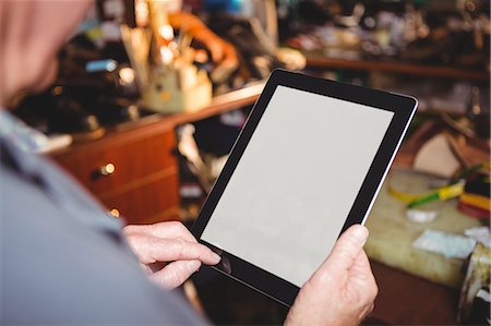 reading a tablet - Shoemaker using digital tablet in workshop Stock Photo - Premium Royalty-Free, Code: 6109-08722916