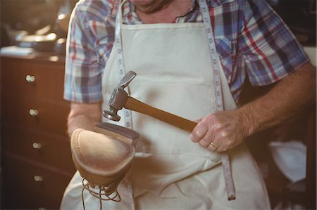 Shoemaker hammering on a shoe in workshop Photographie de stock - Premium Libres de Droits, Code: 6109-08723011