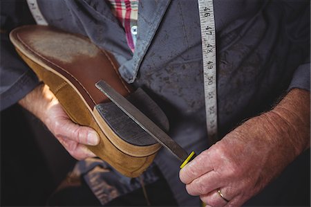 simsearch:6109-08722971,k - Shoemaker repairing a shoe in workshop Foto de stock - Royalty Free Premium, Número: 6109-08723019