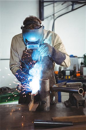 simsearch:6109-08739167,k - Welder welding a metal in workshop Photographie de stock - Premium Libres de Droits, Code: 6109-08739069