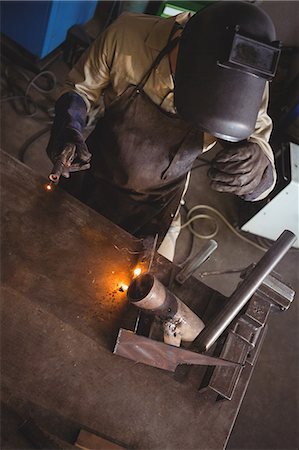 simsearch:6109-08722835,k - Welder welding a metal in workshop Foto de stock - Sin royalties Premium, Código: 6109-08739072