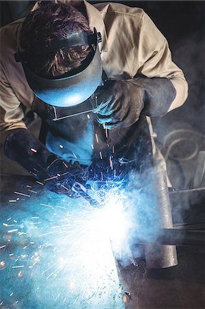 simsearch:6109-08722835,k - Welder welding a metal in workshop Foto de stock - Sin royalties Premium, Código: 6109-08739074