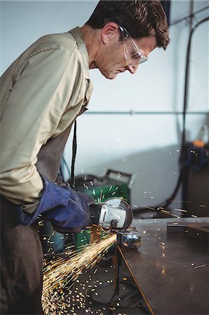 simsearch:6109-08700813,k - Welder cutting metal with electric tool in workshop Photographie de stock - Premium Libres de Droits, Code: 6109-08739081