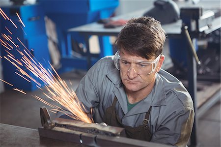 simsearch:6109-08739167,k - Welder cutting metal with electric tool in workshop Photographie de stock - Premium Libres de Droits, Code: 6109-08739098