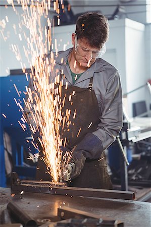 simsearch:6109-08739167,k - Welder cutting metal with electric tool in workshop Photographie de stock - Premium Libres de Droits, Code: 6109-08739099