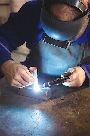 simsearch:6109-08739167,k - Welder welding a metal in workshop Photographie de stock - Premium Libres de Droits, Code: 6109-08739157