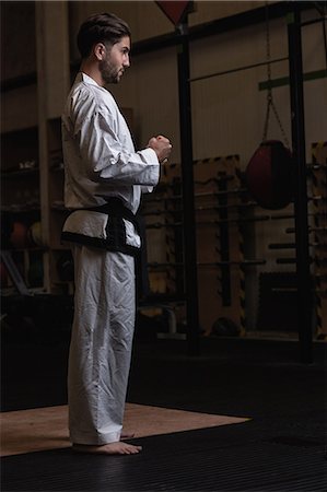 simsearch:6109-08739241,k - Man practicing karate in fitness studio Photographie de stock - Premium Libres de Droits, Code: 6109-08739176