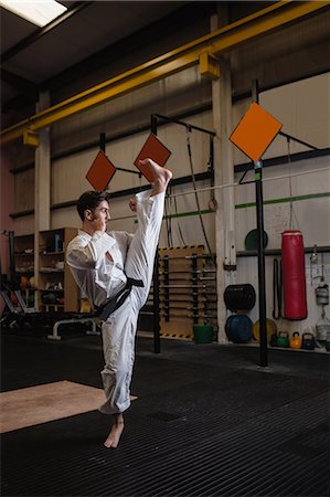 simsearch:6109-08739250,k - Man practicing karate in fitness studio Stock Photo - Premium Royalty-Free, Code: 6109-08739181