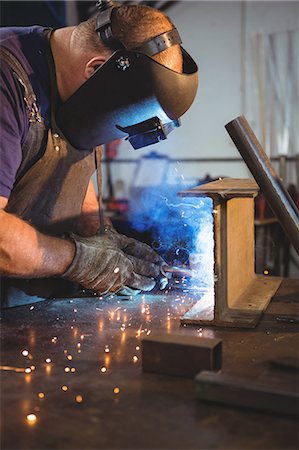 simsearch:6118-08729033,k - Welder welding a metal in workshop Photographie de stock - Premium Libres de Droits, Code: 6109-08739117