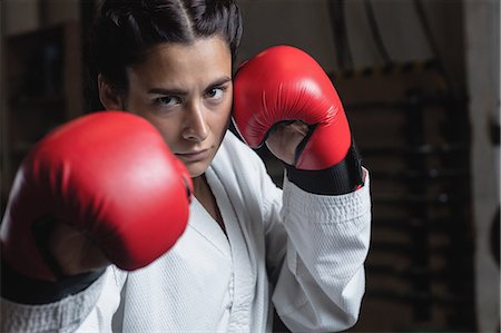 simsearch:858-05799228,k - Portrait of woman in boxing gloves at fitness studio Foto de stock - Sin royalties Premium, Código: 6109-08739245