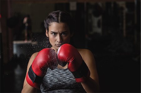 simsearch:6109-08739221,k - Portrait of woman in boxing gloves at fitness studio Stockbilder - Premium RF Lizenzfrei, Bildnummer: 6109-08739280