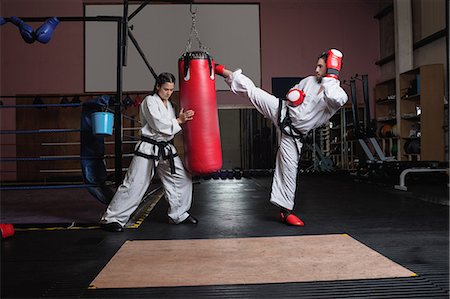 Man and woman practicing karate with punching bag in studio Foto de stock - Sin royalties Premium, Código: 6109-08739200
