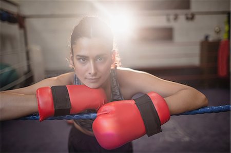 female fighter - Portrait of female boxer in boxing gloves at fitness studio Photographie de stock - Premium Libres de Droits, Code: 6109-08739235