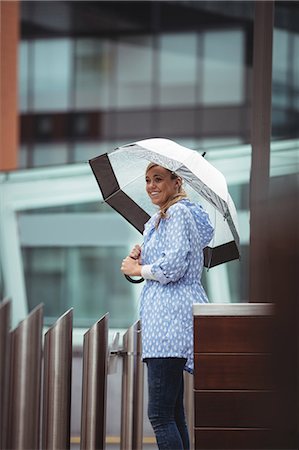 polish ethnicity (female) - Beautiful woman holding umbrella and standing on street during rainy season Stock Photo - Premium Royalty-Free, Code: 6109-08739342