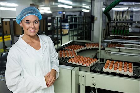 Female staff standing next to conveyor belt in egg factory Fotografie stock - Premium Royalty-Free, Codice: 6109-08739394