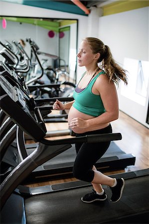 simsearch:6109-08739449,k - Pregnant woman exercising on treadmill at gym Foto de stock - Sin royalties Premium, Código: 6109-08739449