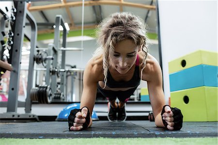 simsearch:6109-08944808,k - Woman performing push-up exercise in gym Stock Photo - Premium Royalty-Free, Code: 6109-08739480