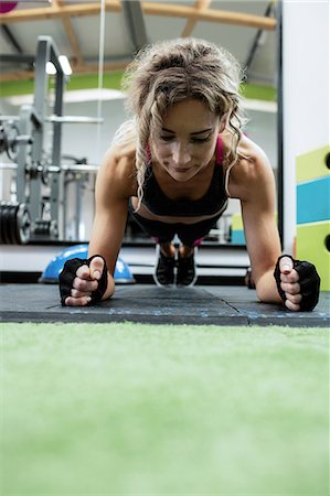 simsearch:6109-08944808,k - Woman performing push-up exercise in gym Stock Photo - Premium Royalty-Free, Code: 6109-08739481