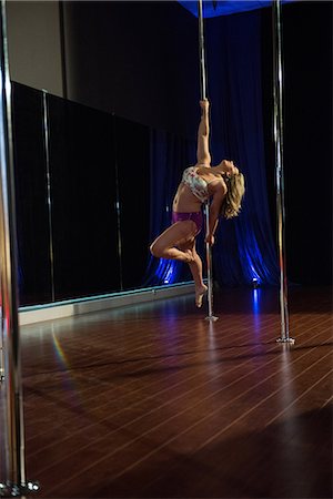 polish ethnicity (female) - Pole dancer practicing pole dance in studio Stock Photo - Premium Royalty-Free, Code: 6109-08739424