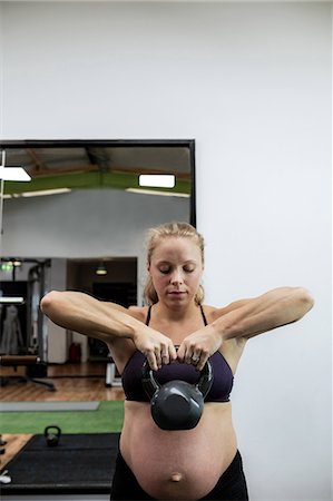 simsearch:6109-08739554,k - Pregnant woman lifting kettlebell in gym Stock Photo - Premium Royalty-Free, Code: 6109-08739553