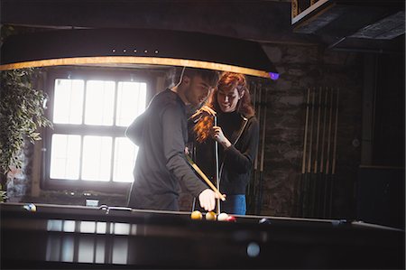 playing pool at a bar - Young happy couple playing pool in bar Stock Photo - Premium Royalty-Free, Code: 6109-08801947