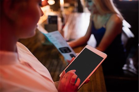 Close up of waitress using digital tablet Stock Photo - Premium Royalty-Free, Code: 6109-08801956