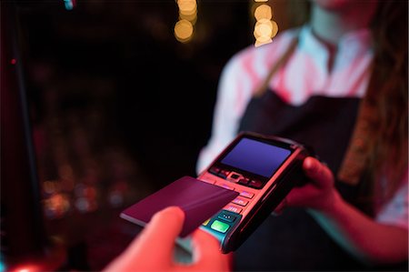 faire glisser la carte - Customer making payment through credit card at counter in bar Photographie de stock - Premium Libres de Droits, Code: 6109-08801983