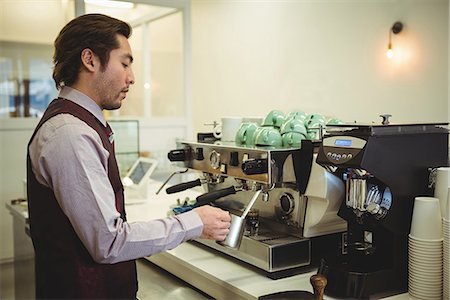 simsearch:6109-08829857,k - Man preparing coffee in coffee machine at coffee shop Foto de stock - Royalty Free Premium, Número: 6109-08802044