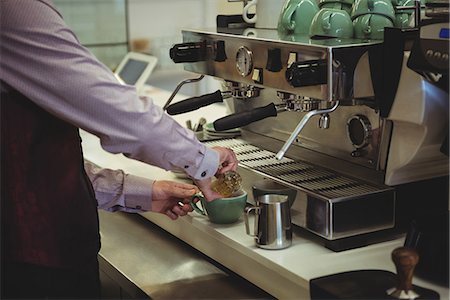 simsearch:6109-08829857,k - Mid section of man preparing coffee in the coffee shop Foto de stock - Royalty Free Premium, Número: 6109-08802046