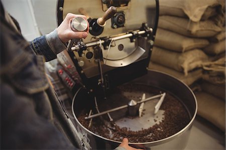 Mid-section of man grinding coffee beans in grinding machine in coffee shop Stock Photo - Premium Royalty-Free, Code: 6109-08802079