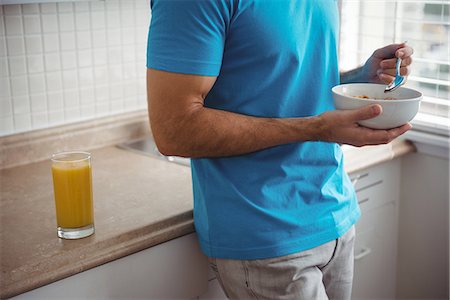 simsearch:6109-08802258,k - Mid section of man having breakfast in the kitchen at home Photographie de stock - Premium Libres de Droits, Code: 6109-08802259