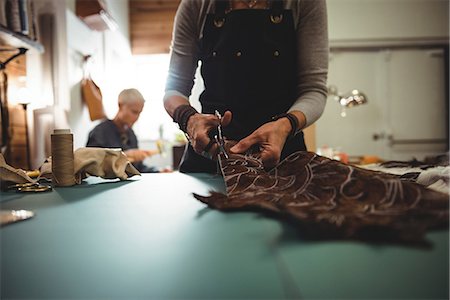 Mid-section of craftswoman cutting leather in workshop Photographie de stock - Premium Libres de Droits, Code: 6109-08802343