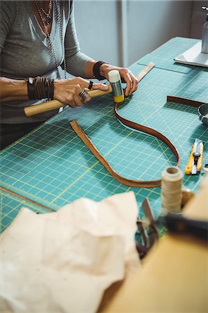 simsearch:649-07905510,k - Mid-section of craftswoman hammering leather in workshop Photographie de stock - Premium Libres de Droits, Code: 6109-08802340