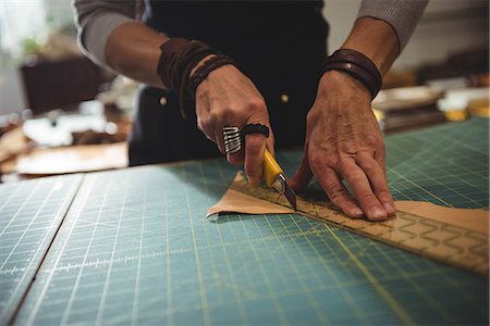 entrepreneur - Mid-section of craftswoman cutting leather in workshop Stock Photo - Premium Royalty-Free, Code: 6109-08802345