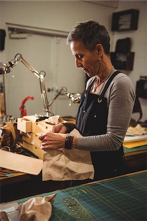 simsearch:614-08821252,k - Craftswoman working on a piece of leather in workshop Stock Photo - Premium Royalty-Free, Code: 6109-08802359