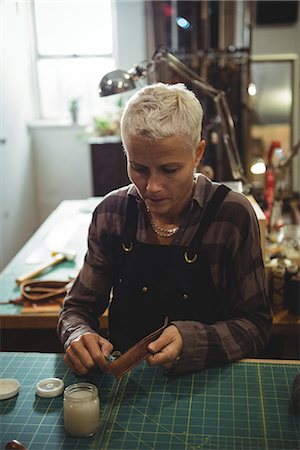 simsearch:614-08821252,k - Attentive craftswoman preparing leather belt in workshop Stock Photo - Premium Royalty-Free, Code: 6109-08802362