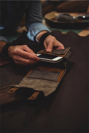 person and cell phone - Craftswoman preparing leather cover for mobile phone in workshop Stock Photo - Premium Royalty-Free, Code: 6109-08802371