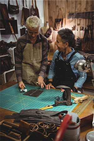 simsearch:614-08821252,k - Craftswomen discussing over a piece of leather in workshop Stock Photo - Premium Royalty-Free, Code: 6109-08802311