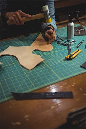 simsearch:649-07905510,k - Mid-section of craftswoman hammering leather in workshop Stock Photo - Premium Royalty-Free, Code: 6109-08802317