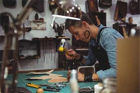 simsearch:649-07905510,k - Craftswoman hammering leather in workshop Photographie de stock - Premium Libres de Droits, Code: 6109-08802318