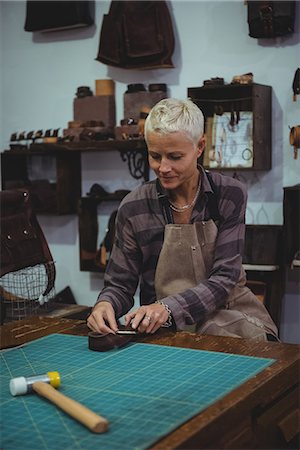 Craftswoman working on a piece of leather in workshop Stock Photo - Premium Royalty-Free, Code: 6109-08802327