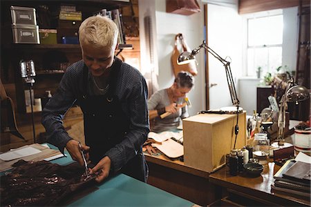 simsearch:614-08821252,k - Attentive craftswoman cutting leather in workshop Stock Photo - Premium Royalty-Free, Code: 6109-08802337