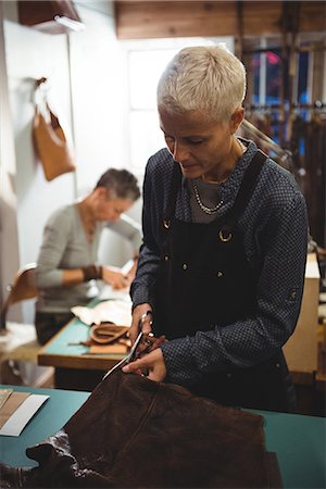 simsearch:614-08821252,k - Attentive craftswoman cutting leather in workshop Stock Photo - Premium Royalty-Free, Code: 6109-08802336