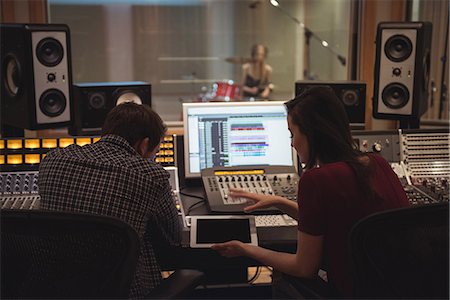 recording studio connecting - Audio engineers using digital tablet while sitting in recording studio Stock Photo - Premium Royalty-Free, Code: 6109-08802469