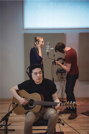 someone singing into a microphone - Music band performing in recording studio Photographie de stock - Premium Libres de Droits, Code: 6109-08802481