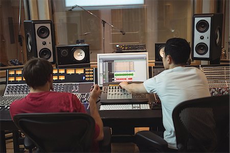 simsearch:6109-08953686,k - Audio engineers using sound mixer in recording studio Foto de stock - Sin royalties Premium, Código: 6109-08802486